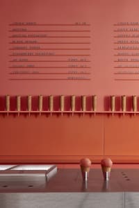 A colorful restaurant scene with a menu board featuring ice cream cones and desserts, displayed on an orange wall with bowls and treats nearby