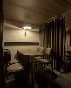 Dimly lit dining space with modern chairs and tables, creating a cozy atmosphere
