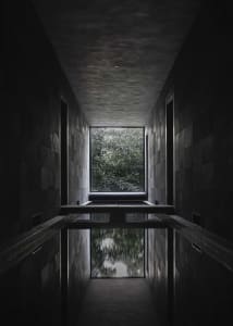 Indoor pool area with stone walls, two benches, and a luxurious atmosphere