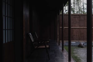 A calm and inviting indoor space with a bench in front of wooden pillars, creating a cozy seating area