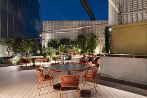 A relaxed outdoor dining area with tables, chairs, and umbrellas, perfect for a night meal