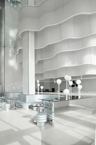 An empty restaurant interior with white walls, dining tables, and chairs, giving a clean and well-organized atmosphere