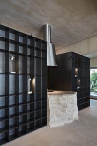 Modern kitchen with a stone countertop island, black theme, and sleek appearance