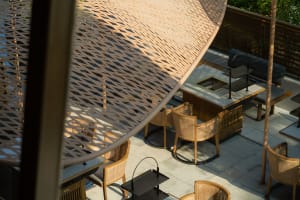 Warm and inviting restaurant interior with wooden tables and chairs, natural light, and a view of the outdoors