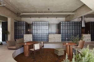 A cozy dining space with a wooden dining table and chairs, a couch, and a vase on the table, set in a warm and inviting atmosphere