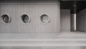 A modern building with a concrete appearance and three round windows on its side, set against a blank background