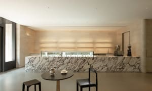 A restaurant dining area with a marble countertop, a dining table, and two chairs, featuring a bowl on the table and a luxurious ambiance