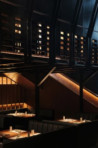 Warm and inviting restaurant interior with wooden floors and walls, featuring dining tables and chairs