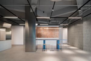 Industrial kitchen with a metal countertop, stools, and a modern atmosphere