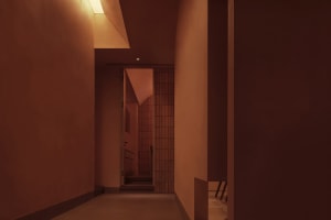 Cozy hallway with a brown brick wall, two chairs, and a doorway leading to another room