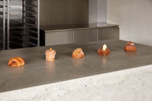 A modern kitchen countertop with four pastries arranged neatly, set against a concrete surface with a sleek appearance