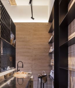 Cozy kitchen space with a wooden countertop, sink, and bottles and a bowl placed on the countertop