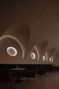 Elegant restaurant interior with concrete walls, multiple chairs, and a focus on functionality and design