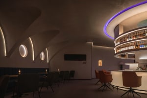 A cozy bar area with a modern counter, surrounded by chairs, creating an inviting atmosphere