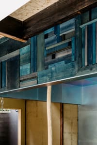 Warm and inviting open kitchen with a large wooden beam, wooden surfaces, and natural materials
