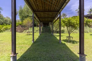 A wooden pavilion with a distinctive design features several benches for seating in a relaxing outdoor environment