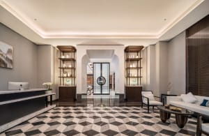 A marble-floored lobby with two chairs and decorative vases, creating a welcoming atmosphere