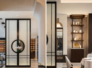 Modern hotel lobby with glass partitions, a large mirror, chairs, and decorative vases, showcasing a spacious and elegant design