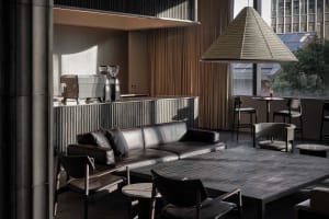Open living area with a couch, chairs, dining table, and coffee maker, designed for relaxation and socializing