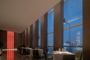 Elegant restaurant interior with tables, chairs, and candlelight, set against a sophisticated backdrop