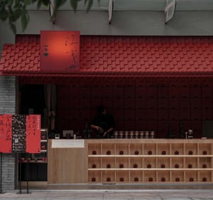 Cozy Asian restaurant with red walls, wooden elements, and traditional decorations, featuring a warm and inviting atmosphere