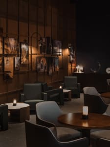 Cozy restaurant interior with wooden walls, tables, and chairs, featuring soft candlelight and a modern design
