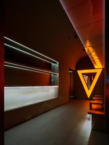 A hotel hallway with wooden paneling, benches, and a welcoming atmosphere
