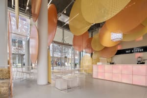 A warm and inviting restaurant space with yellow walls and ceiling, featuring multiple chairs and dining tables for socializing and enjoying meals together