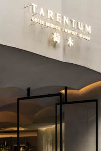 Sophisticated dining space with a bar, wooden chairs, and stone elements, set in a modern Asian restaurant