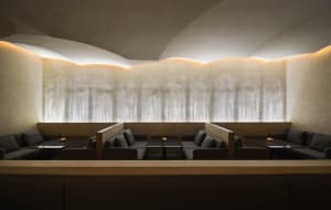 Empty modern restaurant with grey walls, tables, and chairs, creating a calm and inviting atmosphere