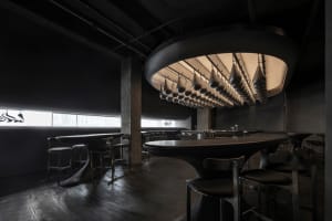 A cozy bar area with a round table surrounded by chairs, wine glasses, and a warm atmosphere
