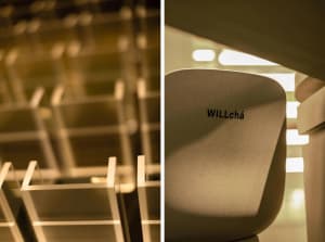 A modern office space with chairs placed throughout, featuring a mix of white and grey tones and a blend of architectural rendering and photography