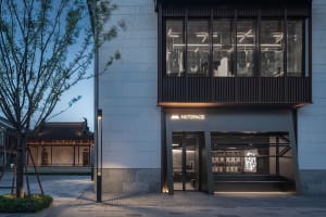 A modern building with a storefront and two large windows, set against a bustling city backdrop
