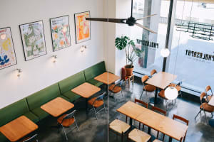 Inviting restaurant interior with wooden tables, chairs, and couches, featuring multiple dining tables and ample seating options