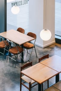 A modern dining space with a large wooden table surrounded by several brown chairs, creating a cozy atmosphere