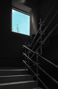 Dark interior staircase with metal railings in a black building with no natural light