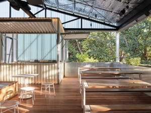 A casual restaurant and bar area with multiple dining tables, chairs, and bottles, creating a relaxed atmosphere for socializing and enjoying food and beverages