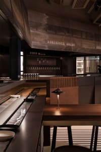 Cozy restaurant interior with wooden tables, chairs, and bottles, creating a warm and inviting atmosphere for dining