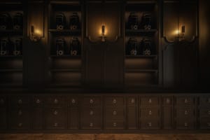 A dark room with an old black cabinet and multiple bottles on various surfaces