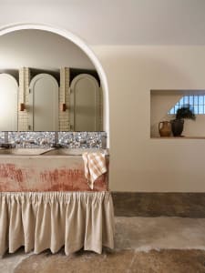 Bathroom with two sinks, mirrors, and brick walls in a vintage design with brown and white tones