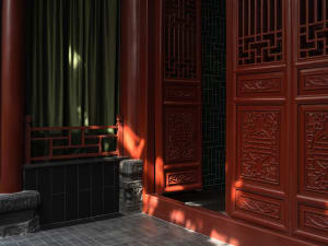 A traditional oriental building with red doors and windows, featuring intricate designs and beautifully painted patterns on the walls