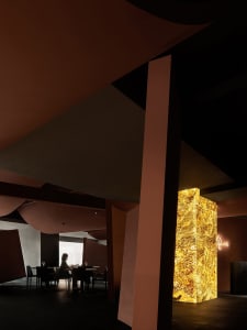 Warm and inviting dining space with wooden tables and chairs, wine glasses, and a cozy atmosphere