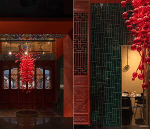 A restaurant with a red room featuring a dining table, chairs, vases, potted plants, and bowls, with a top-down floor plan layout and dimensions