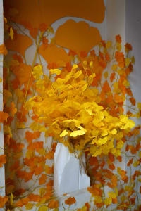 A warm and inviting room with a vase of yellow flowers on a table, creating a beautiful focal point