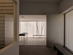 A calm and inviting lobby with two benches, a large window, and natural light