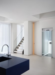 Modern bathroom with a metal staircase, white walls, and a sink in the foreground