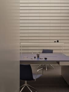 A professional office space with a desk and two chairs, featuring cups and a bowl, in a well-organized atmosphere