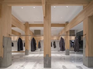 A large hallway with multiple wooden coat racks holding various jackets, creating an organized and functional space