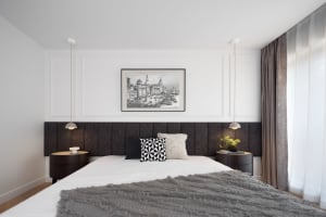 Cozy bedroom with a large bed, a chair, and a painting above the bed