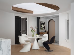Open living area with a dining table, white walls, and a couch, creating a clean and bright atmosphere for relaxation and socializing